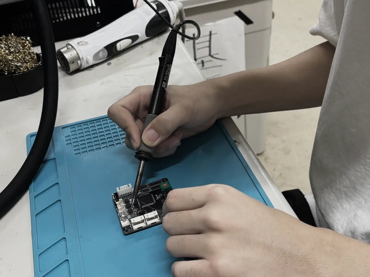 Hands soldering components onto a board